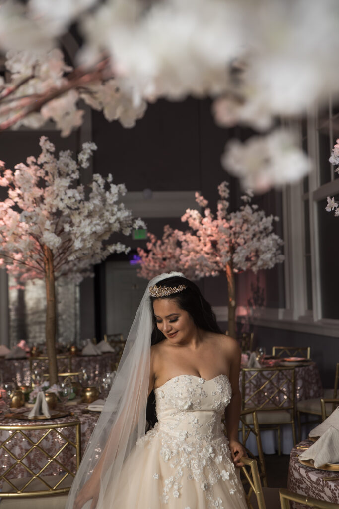 Bride standing beneath crystal chandeliers inside historic Connecticut wedding venue