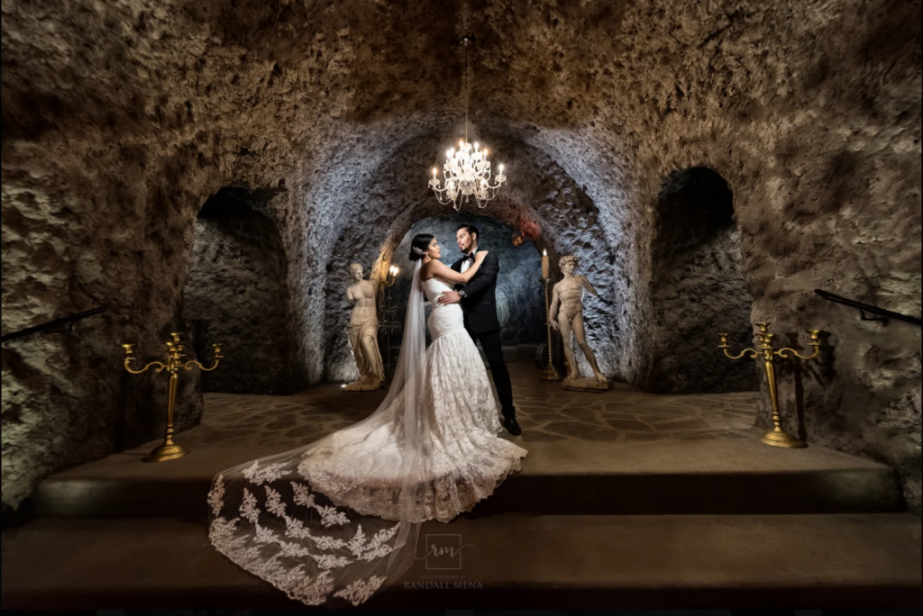 Cinematic wedding portrait featuring elegant ballroom lighting and formal attire in a cave.