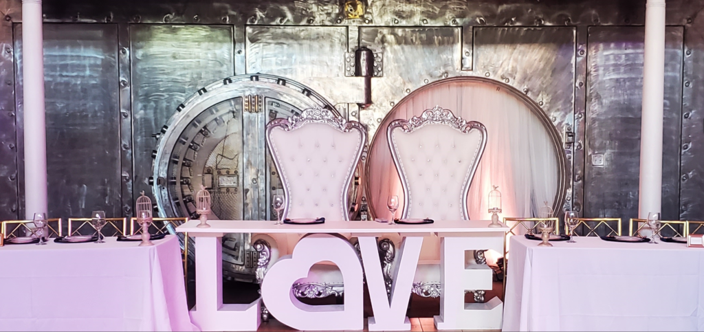 luxury ballroom wedding decor with illuminated LOVE table and historic original 1922 bank vault