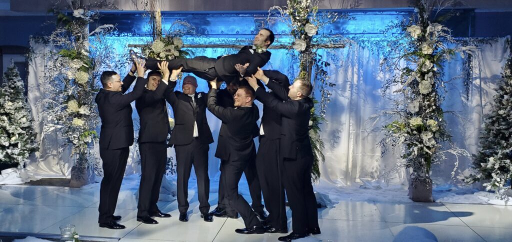 groomsmen celebrating during upscale ballroom wedding reception