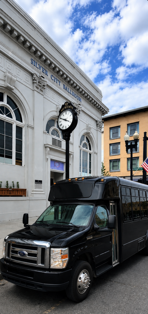 Black wedding guest shuttle outside Silver City Ballroom for private transportation between the hotel and wedding venue.